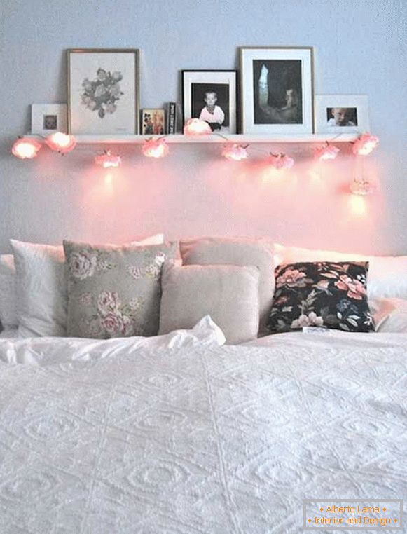 Regal mit kreativer Girlande und Foto, direkt über dem Bett