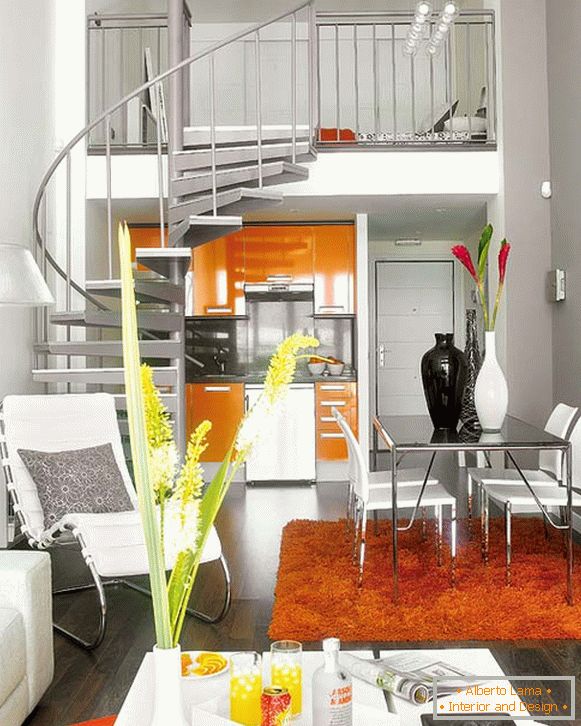 Orange Akzente in einem weißen zweistöckigen Studio-Apartment