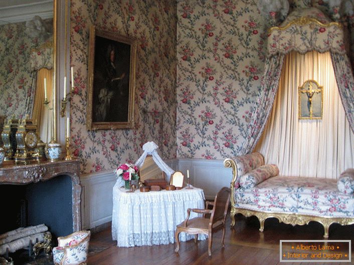 Die farbenfrohe Dekoration der Wände harmoniert mit der Polsterung des Sofas und des Baldachins darüber. Eine barocke Lounge mit einem großen Kamin ist eine großartige Idee für ein Landhaus.