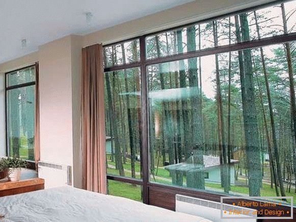 Schlafzimmer mit großen Fenstern in einem privaten Haus