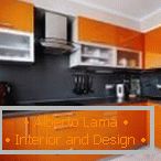 Flache schwarze Schürze in der orange Küche