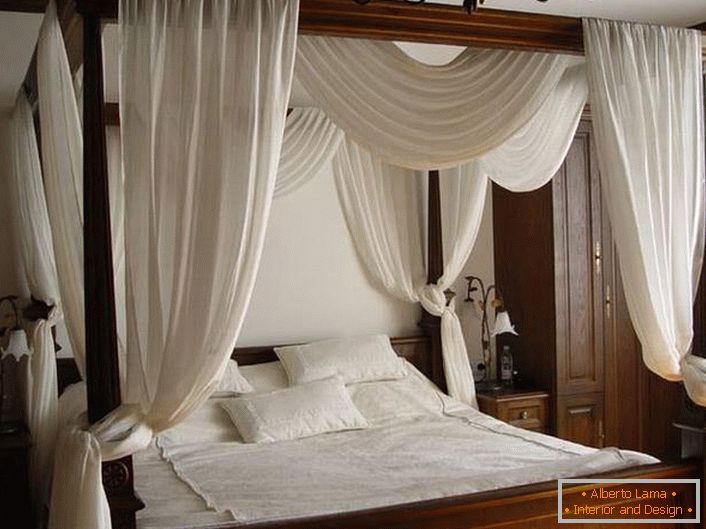 Ein weißer Baldachin über einem einfachen, lakonischen Bett aus Holz.