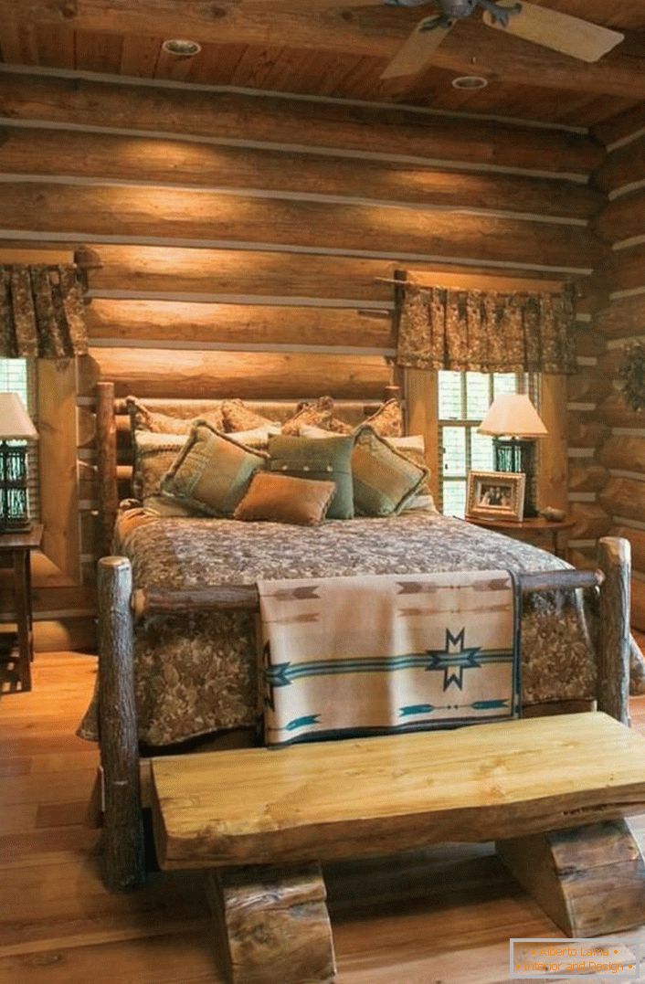 Ein klassisches Beispiel für ein Schlafzimmer im rustikalen Stil. Interessantes Bett eines unbehandelten Blockhauses. 