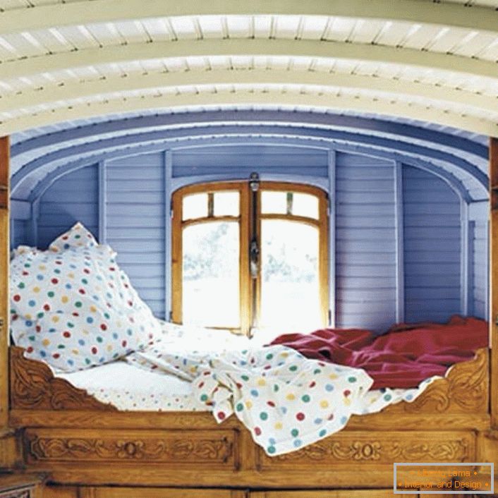 Minimale Details im Schlafzimmer im rustikalen Stil. Der Designer wählte einen ungewöhnlichen Standort für das Bett. Ein kleines Bett direkt am Fenster ist das perfekte Bett für Träumer.