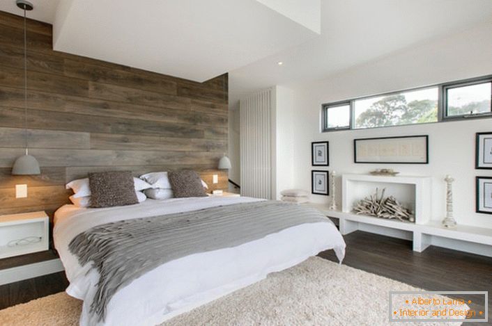 Ein stilvolles Schlafzimmer in rustikalem Land. Der funktional gestaltete Raum ist nicht mit unnötigen Details überladen. Das Schlafzimmer ist das richtige Beispiel für ein Familienheim.