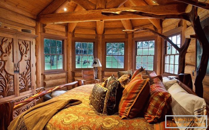 Eines der Schlafzimmer im Haus am See ist im ländlichen Stil gestaltet. Holzdekoration. Massive Möbel und Dekorelemente werden in den besten Stiltraditionen ausgewählt.