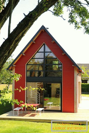 Innenraum eines kleinen Holzhauses mit großen Fenstern