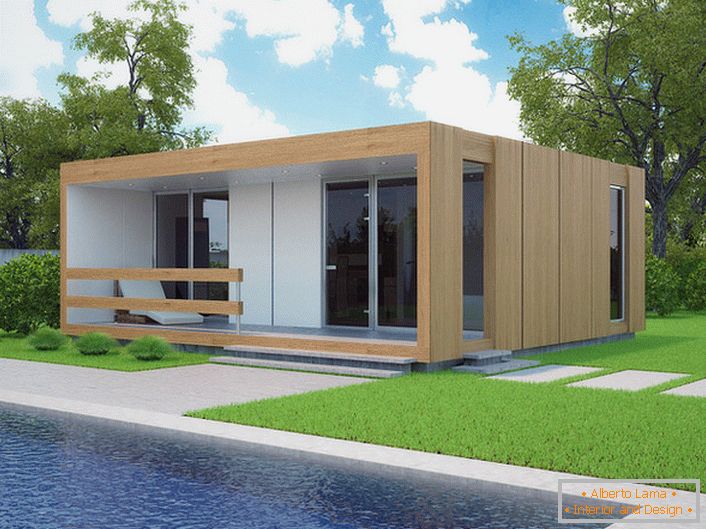 Ein kleines modulares Haus mit einem Schwimmbad im Hof. Das stilvolle Design eines schnell gebauten Hauses wirkt organisch vor dem Hintergrund eines kurz geschnittenen Rasens.