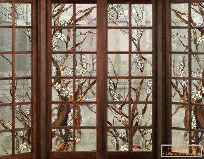 Die Fenster im dunklen Holzrahmen sind mit Buntglas verziert. Unkomplizierte Figur geeignet für die Inneneinrichtung im Landhausstil oder modern.