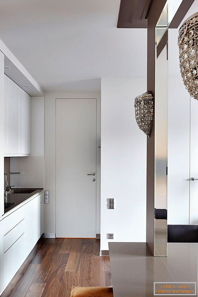Weiße Küchenmöbel, weiße Eingangstür und schönes Holzparkett