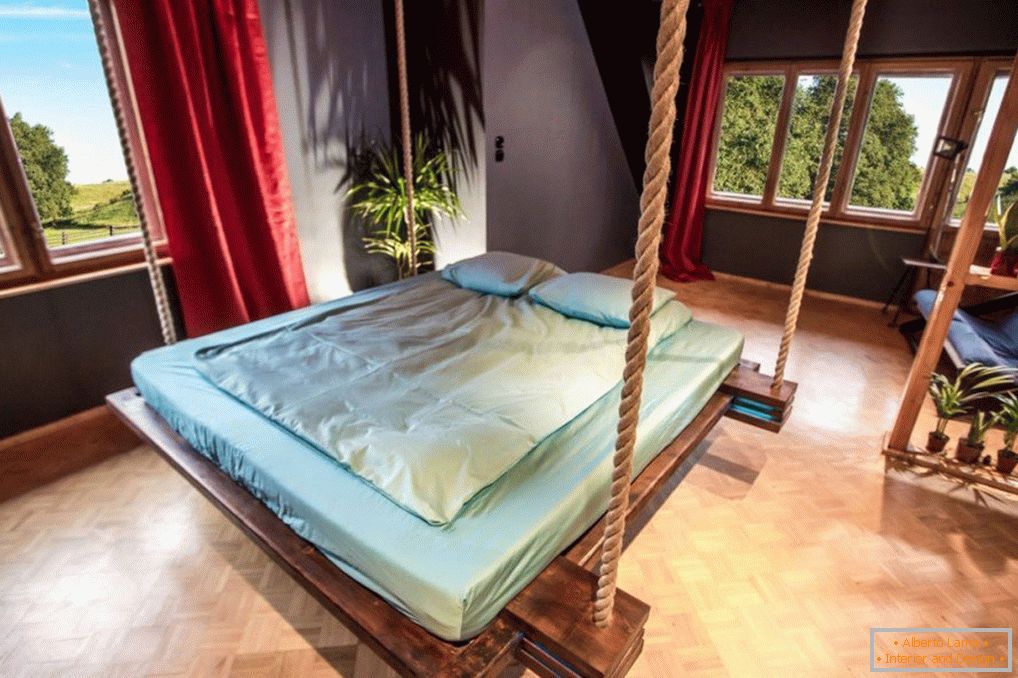 Schlafzimmer mit Bett an Seilen