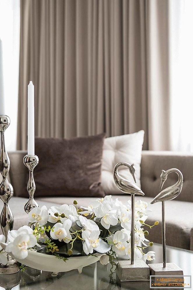Zusammensetzung von Orchideen, von Kerzen und von anderen dekorativen Elementen auf dem Tisch im Wohnzimmer