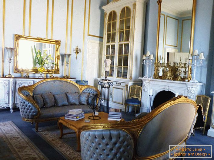 Das Wohnzimmer im Empire-Stil ist in sanften Blautönen gehalten, die sich harmonisch in die goldenen Elemente des Dekors einfügen. Framing Spiegel und geschnitzte Möbelelemente sind in einem einheitlichen Stil hergestellt.