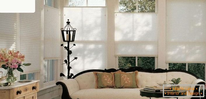 Moderne einfarbige, luftdurchlässige Vorhänge plissieren nicht die raffinierte Atmosphäre des Wohnzimmers eines alten Landhauses. 