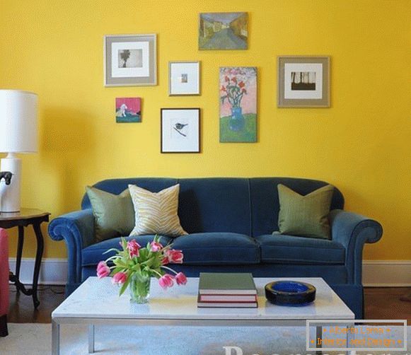 Blaues Sofa auf einem gelben Wandhintergrund