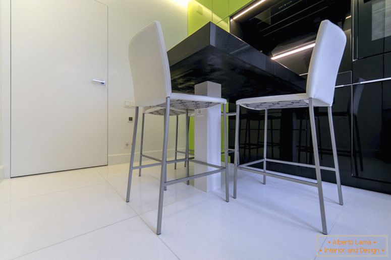 Weiße Stühle auf dem Hintergrund der schwarzen und grünen Küche