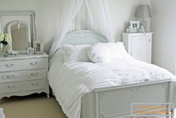 Romantisches Schlafzimmer mit weißem Bett und Dekor
