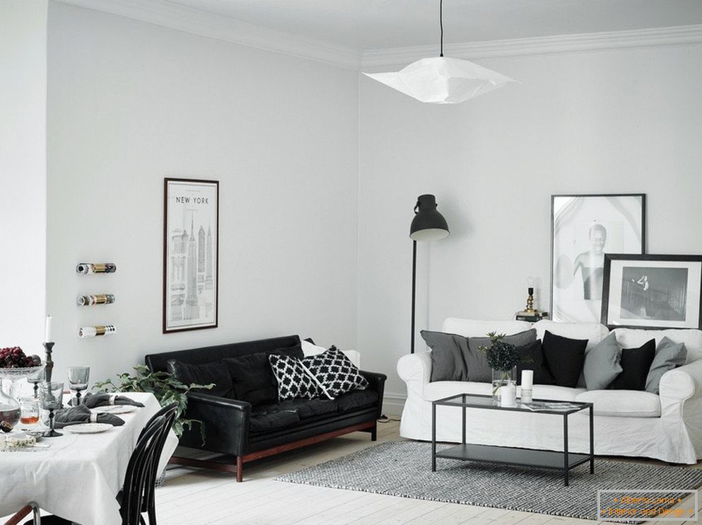 Wohnzimmer ist weiß mit einem schwarzen Sofa