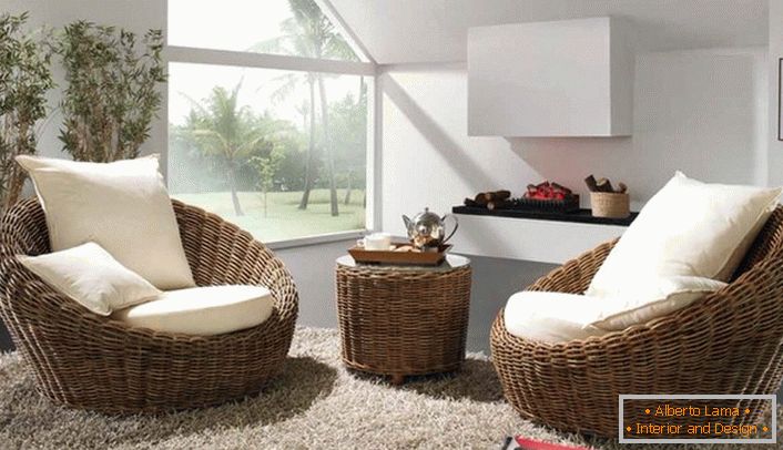 Wicker voluminösen Sessel mit weißen weichen Kissen mit einem Teppich mit einem hohen Stapel abgeschlossen ist die beste Dekoration des Gästezimmers in Öko-Stil.