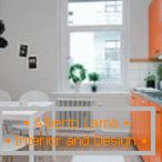 Weiße Küche mit orangefarbenen Möbeln