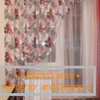 Vorhang mit Blumen auf dem Küchenfenster