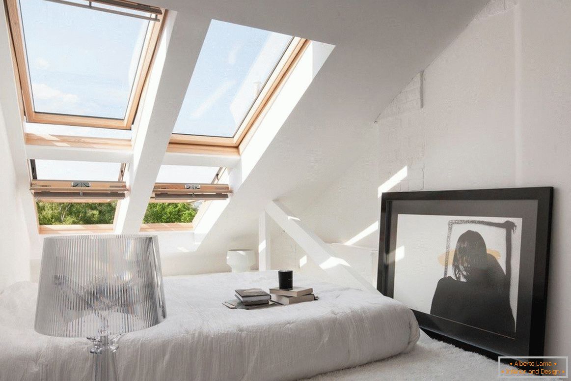 Gemütliches Schlafzimmer mit Fenstern auf der Dachschräge