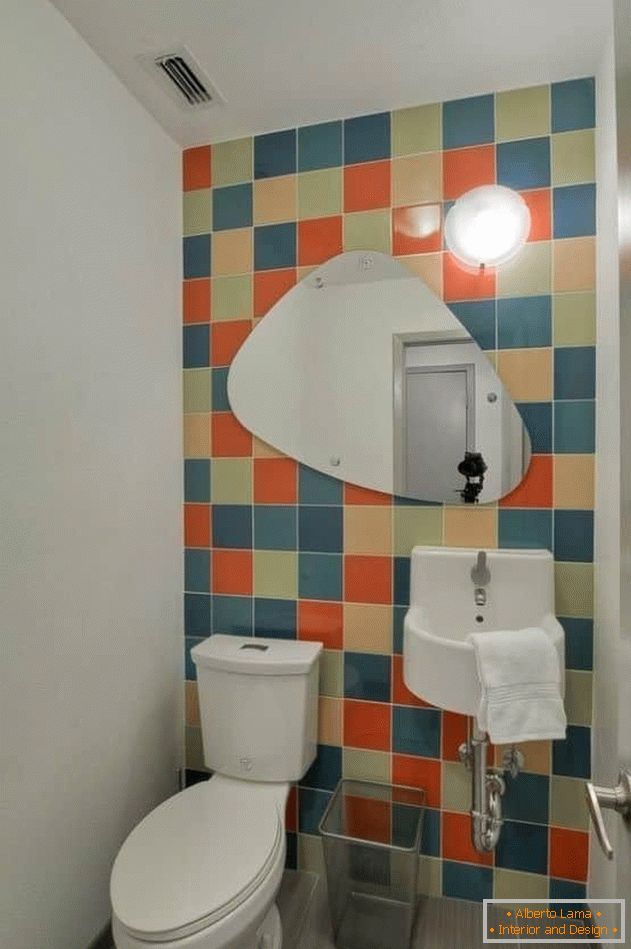 Kleine Toilette mit hellen Fliesen und bemalten Wänden