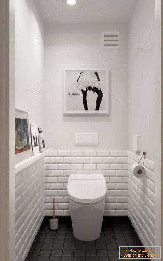 Eine kleine Toilette in Weiß mit einem dunklen Boden