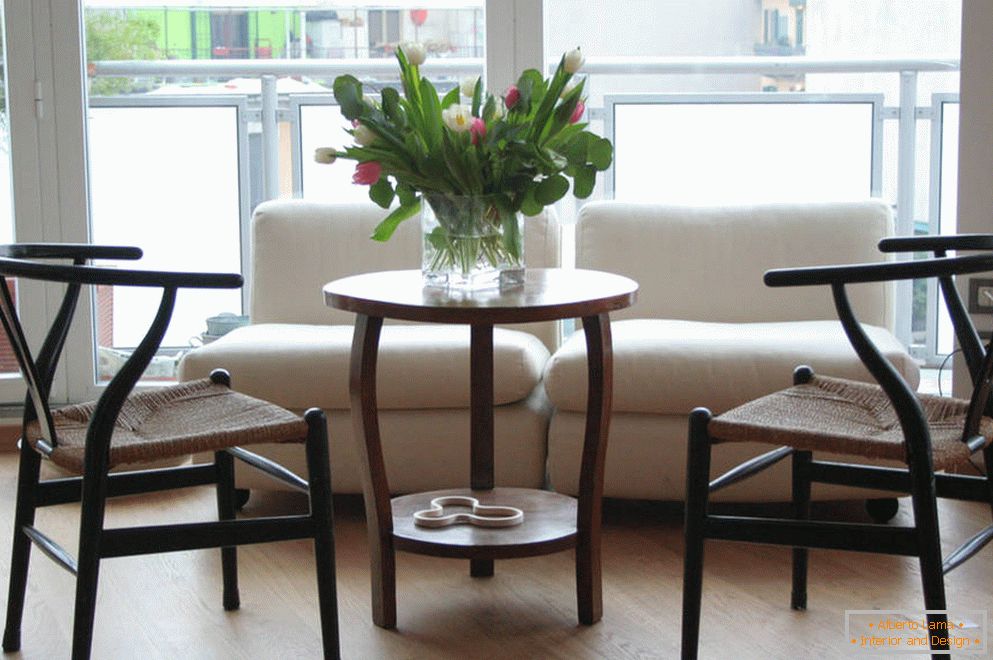 Ungewöhnliche Stuhlformen und ein Tisch mit Blumen