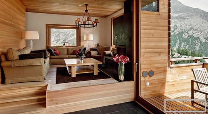 Das Dachgeschoss der Villa mit Zugang zur Veranda ist im Stil eines Chalets eingerichtet. Die Farbe von hellem Holz wirkt gewinnbringend in Kombination mit einer dunkelbraunen Bodenfliese.