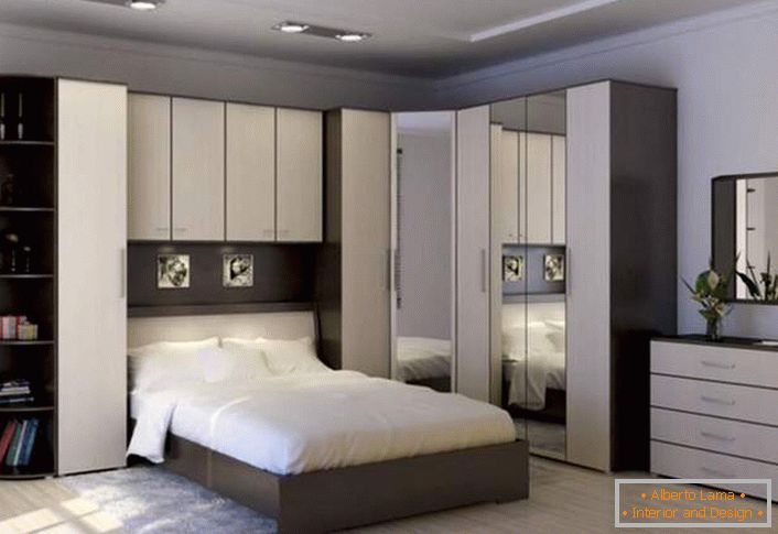 Funktionelle Eckwand für das Schlafzimmer. Der richtig gestaltete Raum bleibt geräumig und nicht überladen. Ein Platz zum Speichern ermöglichen Klappfächer über dem Bett.