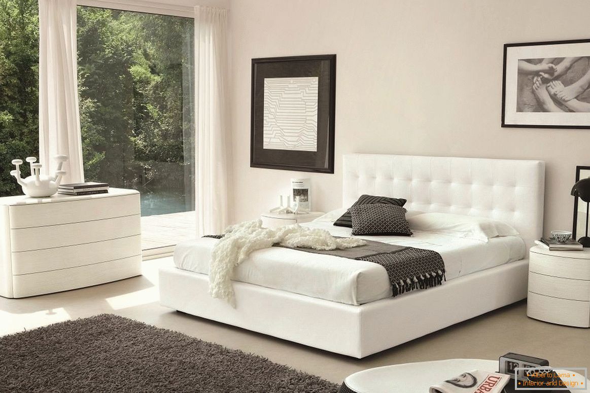 Weißes Bett, Kommode und Nachttisch im Schlafzimmer
