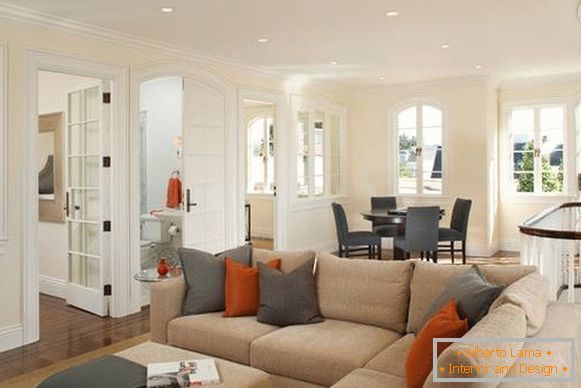 Die Kombination von Grau und Orange im Inneren des Wohnzimmers