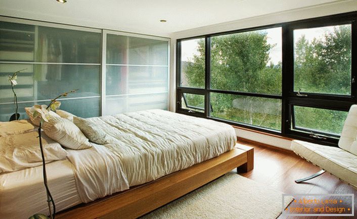Ein niedriges Holzbett fügt sich harmonisch in das Jugendstil-Interieur des Schlafzimmers ein.