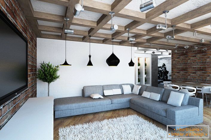 Gemütliches helles Wohnzimmer im Loft-Stil. Harmonische Kombination von gemauerten Ziegelwänden und massiven Balken. 