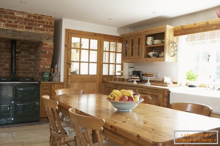 Geräumige Küche im Landhausstil. Holzmöbel und Ziegelsteindekoration über dem Ofen geben dem Stil eine natürliche und romantische Note.