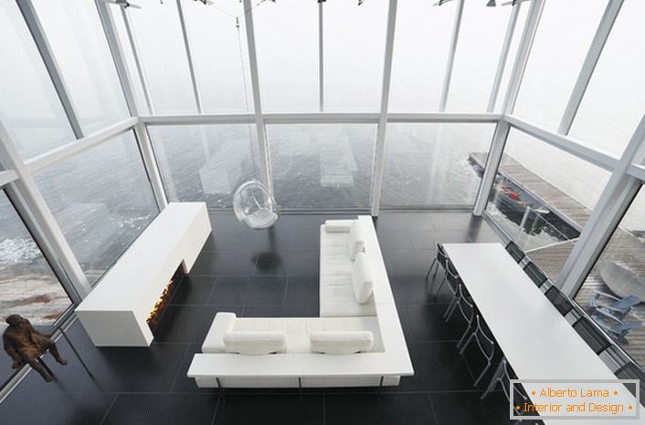 Lakonische Gestaltung des Wohnzimmers im minimalistischen Stil. Ein interessantes Möbelstück ist ein Stuhl, der an einer hohen Decke hängt.
