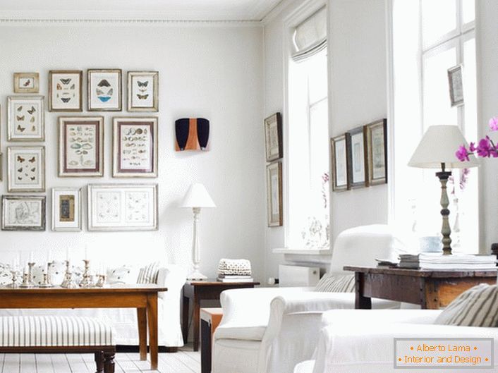 Ein gemütliches Wohnzimmer im skandinavischen Stil ist in weiß gehalten. Es ist interessant, die Wand mit Rahmen in verschiedenen Größen zu dekorieren.