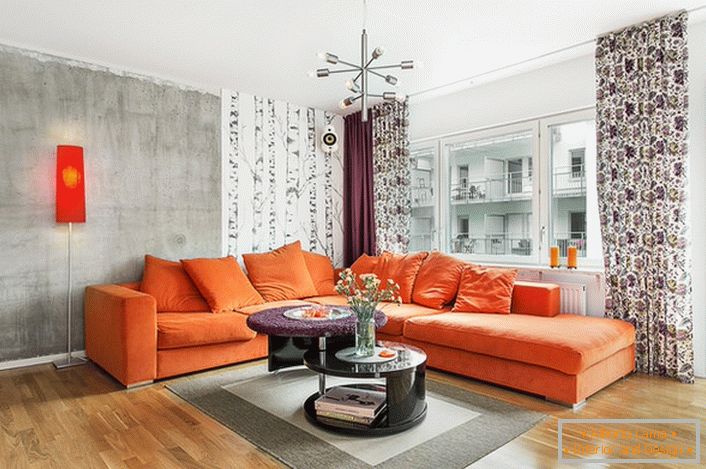 Skandinavischer Stil ist in der Verwendung von warmen Farben in der Innenarchitektur inhärent. Sanftes orange Sofa sieht organisch auf dem Hintergrund der Wände eines kalt-grauen Farbtons aus.