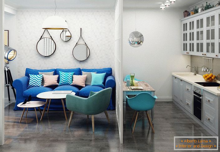 Das dunkelblaue Sofa kontrastiert mit dem hellen Finish. Ein Beispiel für ein gelungenes Design einer kleinen Einzimmerwohnung.