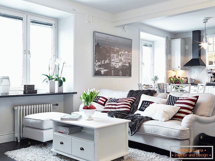 Ein gemütliches Studio-Apartment im skandinavischen Stil ist überwiegend in Weiß gehalten. Fenster ohne Vorhänge lassen genug Tageslicht in den Raum.