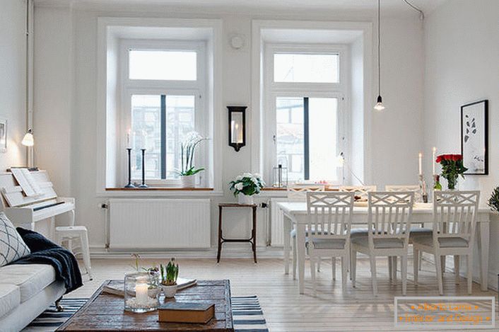Das stilvolle Wohnzimmer ist in einen Sitzbereich und einen Essbereich unterteilt. In Anlehnung an den skandinavischen Stil sind die Wände des Raumes in Weiß gehalten.