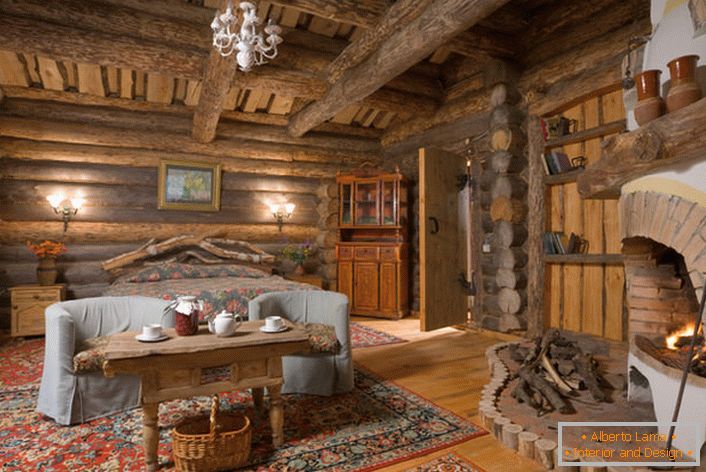 Rustikales Land mit einem großen Schlafzimmer eines Landhauses in Skandinavien. In jedem Interieur, das in einem rustikalen Stil ausgeführt wird, wird der Kamin harmonisch aussehen, besonders aus einem Ziegelstein. 