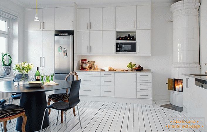 Der geflieste Kamin mit weißen Keramikfliesen passt organisch in das skandinavische Interieur der Küche.
