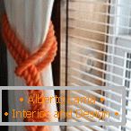 Weißer Vorhang und orange Seil