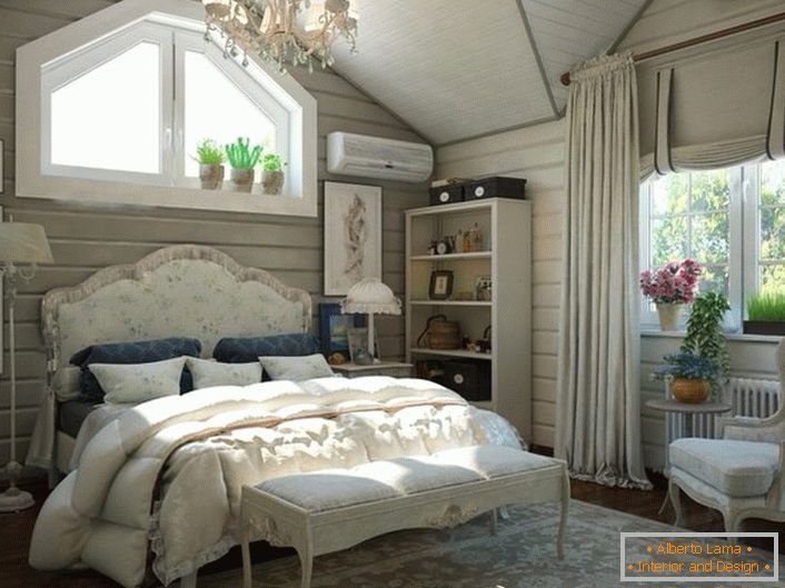 Ein Schlafzimmer für Gäste im Dachgeschoss eines Landhauses. Das Interieur im Landhausstil wirkt beeindruckend und stilvoll. 