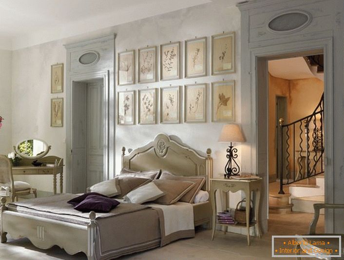 In Übereinstimmung mit den Traditionen des französischen Stils für das Schlafzimmer wurde lakonische Möbel aus Holz ausgewählt. Ein interessantes Detail ist eine Collage von Bildern über dem Kopf des Bettes.