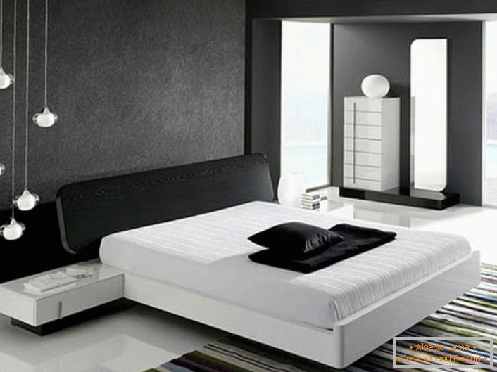 Die Wand im oberen Teil des Bettes, dekoriert mit einem grauen, matten Einsatz, entspricht dem Stil von High-Tech und harmoniert mit dem glänzend weißen Boden.
