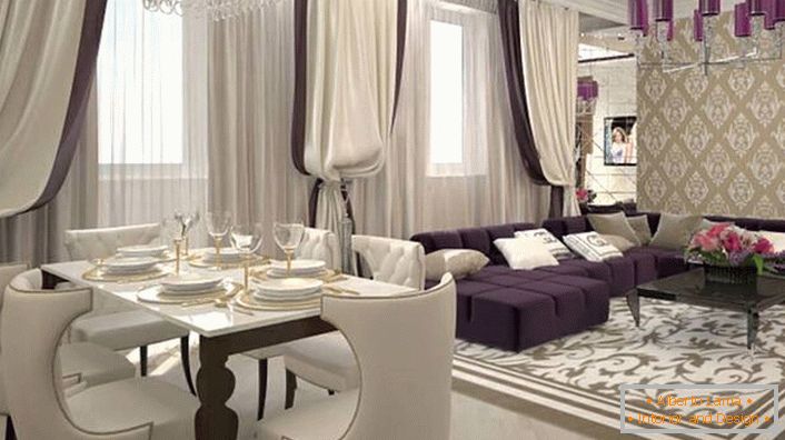 Schwere Vorhänge an den Fenstern in Kombination mit weichen weiß-lila Möbeln kombinieren, um das Interieur im Stil von Art Deco neu zu erstellen. Passend zum Stil wird auch die Beleuchtung ausgewählt. Der Deckenleuchter ist mit den gleichen glänzenden Schattierungen von dunkelviolett verziert.