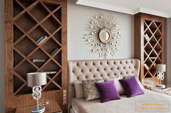 Das weiche Kopfteil eines luxuriösen Doppelbettes besteht aus natürlichem, gestepptem Satin. An den Seiten des Bettes sind hohe dekorative Regale, wo der Besitzer seine Lieblingsbücher hinzufügen kann. 